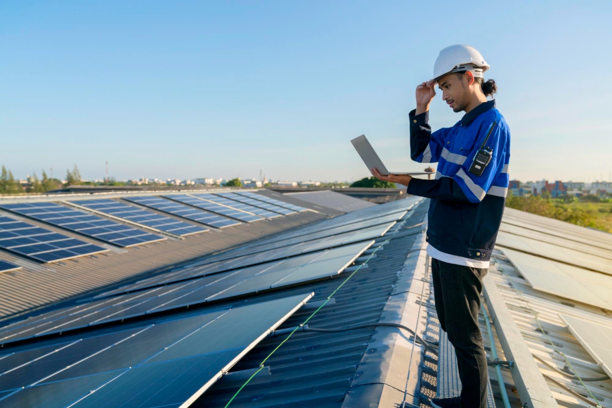 muž na střeše se solárními panely